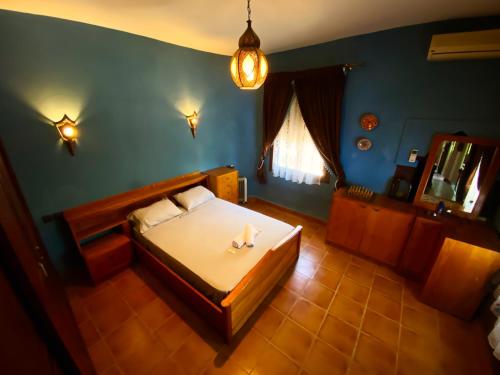 ein Schlafzimmer mit einem Bett und einer blauen Wand in der Unterkunft Villa Authentique avec Vue Panoramique à 3 km de Chefchaouen in Chefchaouen