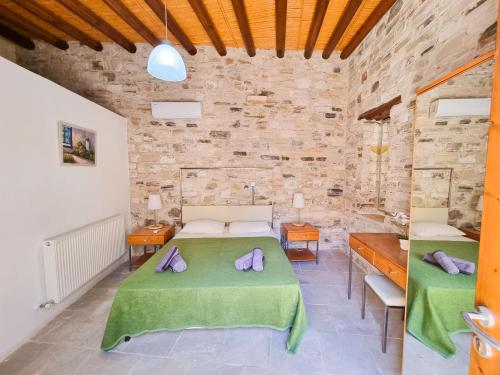 1 dormitorio con 2 camas y pared de piedra en Traditional Village Pool Paradise Family Apartment, en Skarinou