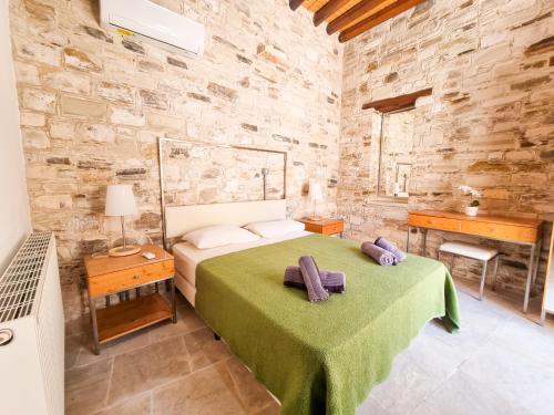 1 dormitorio con 1 cama en una pared de piedra en Traditional Village Pool Paradise Family Apartment, en Skarinou