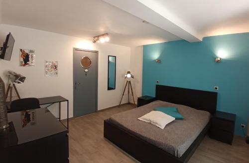 une chambre avec un lit et un mur bleu dans l'établissement Sur les pas de Pagnol, à Aubagne