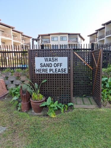 a gate with a sign that reads wash sand off here please at 24 Topanga in Uvongo Beach