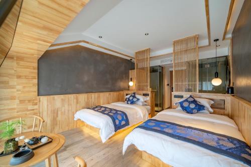 a bedroom with two beds and a table at Cozy Boutique Hotel in Zhangjiajie