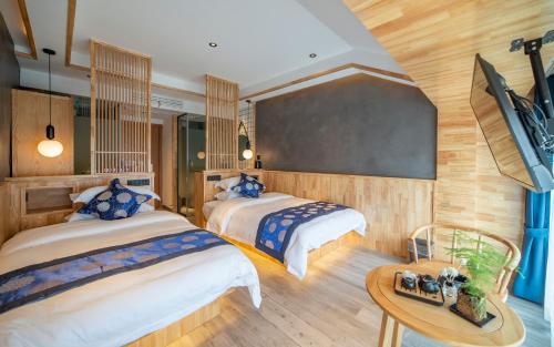 a bedroom with two beds and a table in a room at Cozy Boutique Hotel in Zhangjiajie