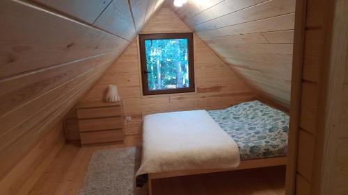 a small bedroom with a bed and a window at Pasieka Dobro i Smak in Borzymy