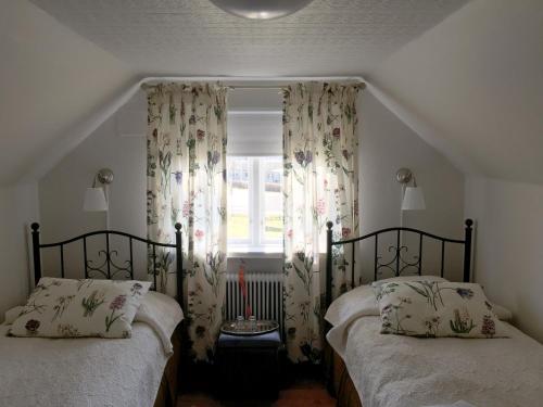 two twin beds in a bedroom with a window at Furuliden Country Inn in Vittsjö