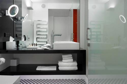 a bathroom with a sink and a mirror and towels at Renaissance Warsaw Airport Hotel in Warsaw