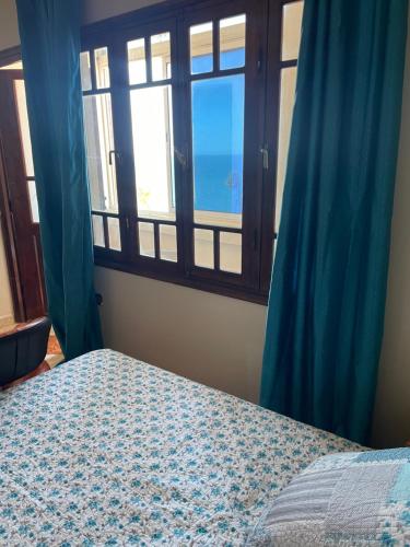 Schlafzimmer mit einem Bett und einem Fenster mit Meerblick in der Unterkunft Vu sur corniche in Safi