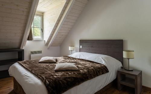 a bedroom with a large bed with two pillows on it at Lagrange Vacances Le Clos Saint Hilaire in Saint-Lary-Soulan