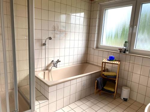 a bathroom with a bath tub and a window at PferdeFairStand‘s Ferienwohnung in Haunetal
