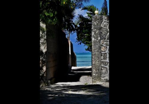 a path to the beach through an archway at Amka House in Jambiani
