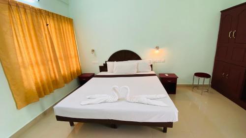 a bedroom with two beds with white towels on them at Packbag Comfort Bed & Breakfast in Kovalam