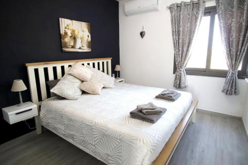 Un dormitorio con una cama blanca con almohadas y una ventana en The Summer Haven, en Polis Chrysochous