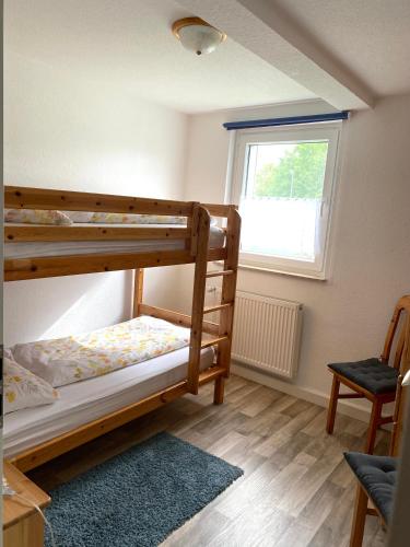 a bedroom with two bunk beds and a window at PferdeFairStand‘s Ferienwohnung in Haunetal