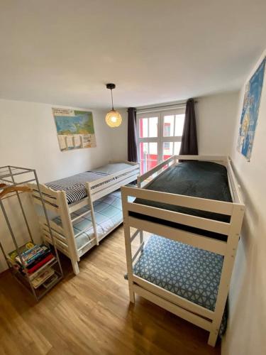 une chambre avec deux lits superposés et une fenêtre dans l'établissement Gîte la Maison Rouge Béthune, à Béthune