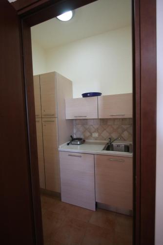 a small kitchen with white cabinets and a sink at Poseidon in Ispica