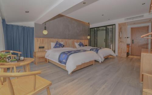 a large bedroom with two beds and a table at Cozy Boutique Hotel in Zhangjiajie