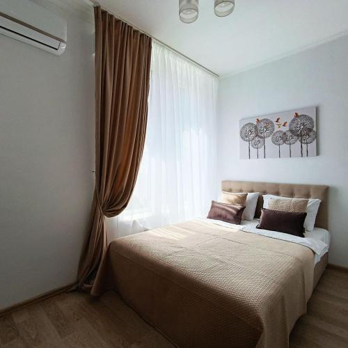 een slaapkamer met een groot bed en een groot raam bij Смарт квартира в ЖК Комфорт Таун in Kiev