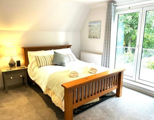 a bedroom with a bed and a large window at Number 8 in Midhurst