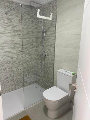 a bathroom with a toilet and a glass shower at villamar III in San Pedro del Pinatar