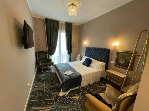 a hotel room with a bed and a chair at Prestige Suite Via Romagnoli in Sirmione