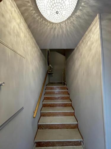 a staircase with a ceiling with a chandelier at Prestige Suite Via Romagnoli in Sirmione