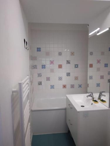 une salle de bain blanche avec un lavabo et une douche dans l'établissement Studio tout confort, à Lamoura