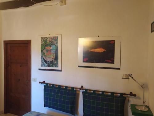 Habitación con 2 cuadros en la pared y 2 toallas en Casa Alice en Rio nellʼElba