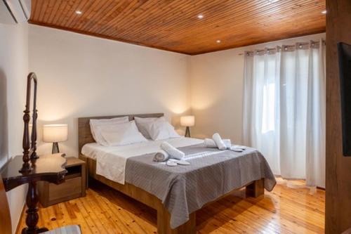 a bedroom with a large bed with a wooden ceiling at Guest house (Gastouri) in Gastouri