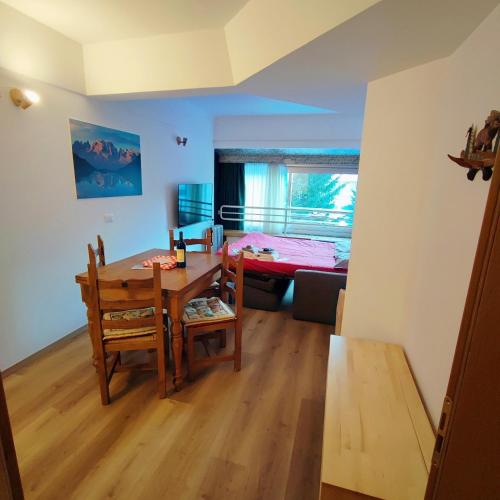 um quarto com uma mesa e cadeiras e uma sala de jantar em Genziana Apartment - CIPAT 22114 em Marilleva