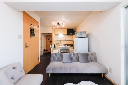 a living room with a couch and a kitchen at Grace Heiwajima by Tranova in Tokyo