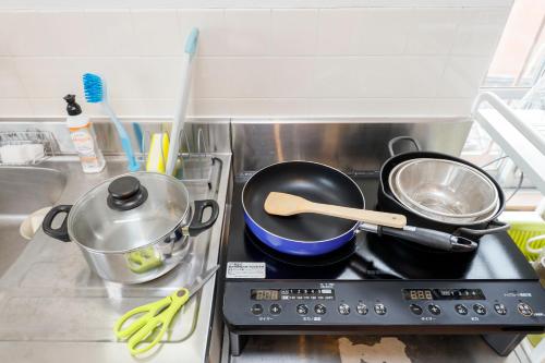 a stove top with pots and pans on it at Grace Heiwajima by Tranova in Tokyo