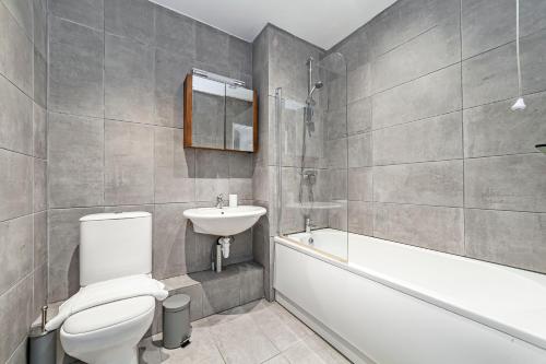 ein Badezimmer mit einem WC, einem Waschbecken und einer Badewanne in der Unterkunft The Brixton Collection in London