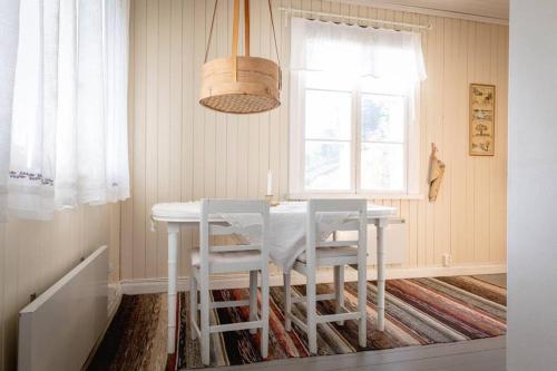 a dining room with a white table and chairs at Trevligt fritidshus 20 km utanför Falun Dalarna in Falun