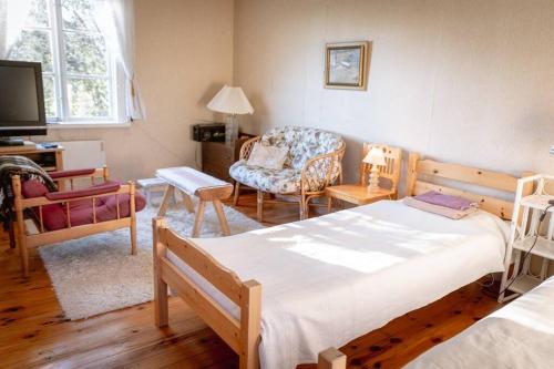 sypialnia z 2 łóżkami, krzesłem i kanapą w obiekcie Trevligt fritidshus 20 km utanför Falun Dalarna w mieście Falun