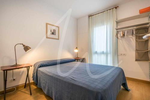 カレリャ・デ・パラフルジェリにあるXaloc by SeaMount Rentalsのベッドルーム(青いベッド1台、窓付)