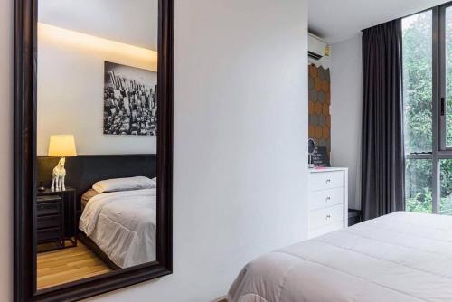 a bedroom with a large mirror on the wall at Vinn condo in Amphoe Phra Khanong
