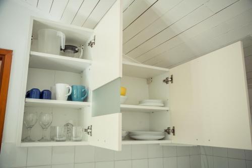 eine Küche mit weißen Regalen und Geschirr darauf in der Unterkunft Felix Apartment Biograd in Biograd na Moru