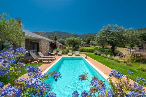 a swimming pool in a yard with flowers at Avista Private Resort in Vourvourou