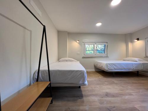 1 dormitorio con 2 camas y ventana en Hostal Mindanao, en Salamanca