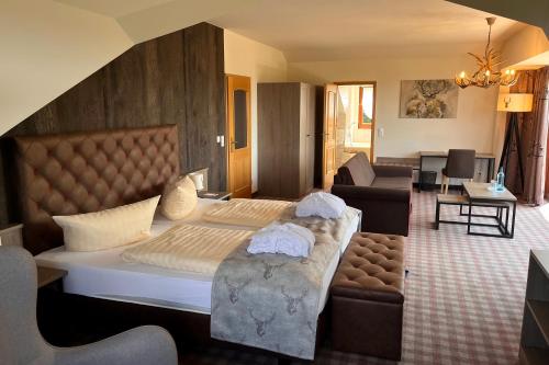 a bedroom with a large bed and a living room at Augustusberg Hotel & Restaurant in Bad Gottleuba