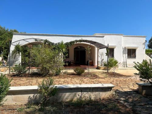 a white house with a courtyard in front of it at Sol Invictus Est in Serranova