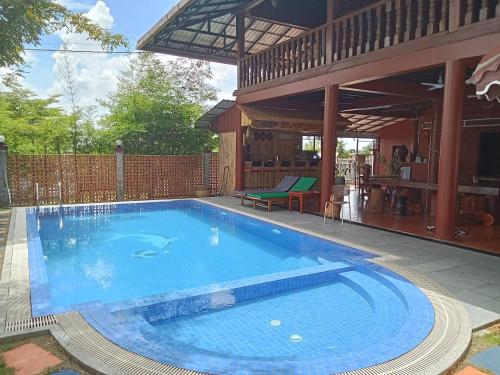 a large swimming pool in the backyard of a house at Domnak Teuk Chhou in Kampot