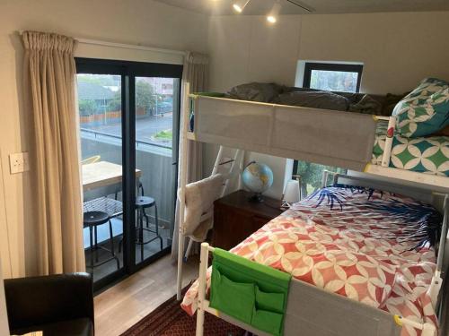 a bedroom with a bunk bed and a balcony at Deer Park Apartment CPT - With Sweeping Views in Cape Town