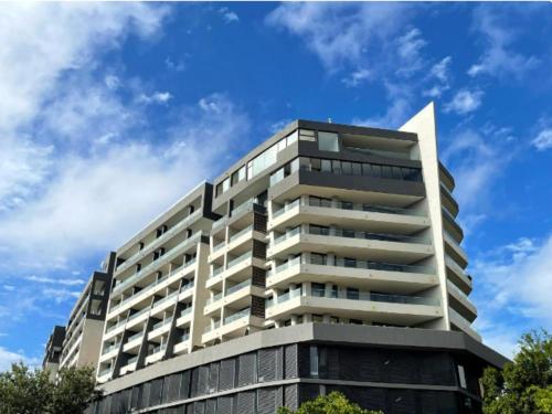 a tall building with a blue sky in the background at Newlands Peak - Spacious one-bed apartment in Cape Town