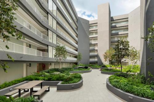 an internal courtyard of a building with benches and trees at Newlands Peak - Spacious one-bed apartment in Cape Town