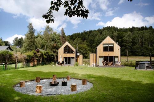 a house with a fire pit in the middle of a yard at Babia Rest - całoroczny domek z balią z jacuzzi in Zawoja