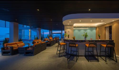 a bar in a building with orange chairs and tables at Luxury Apartment - Rooftop Swimming Pool - Beach Front - Hinata Apartment in Da Nang