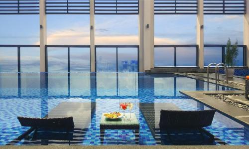 a pool with a table with drinks on it at Luxury Apartment - Rooftop Swimming Pool - Beach Front - Hinata Apartment in Da Nang