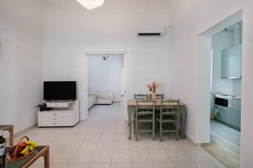 a living room with a kitchen with a table and a television at Piraiki Coastal Accommodation in Piraeus