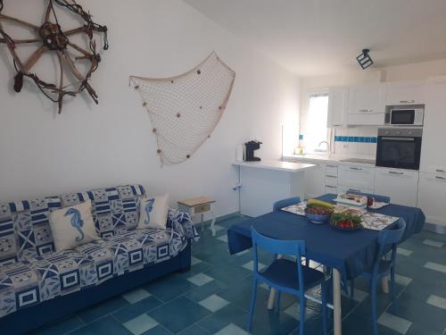 een woonkamer met een blauwe tafel en een bank bij Villa la Torre Maestrale in Torre Dei Corsari